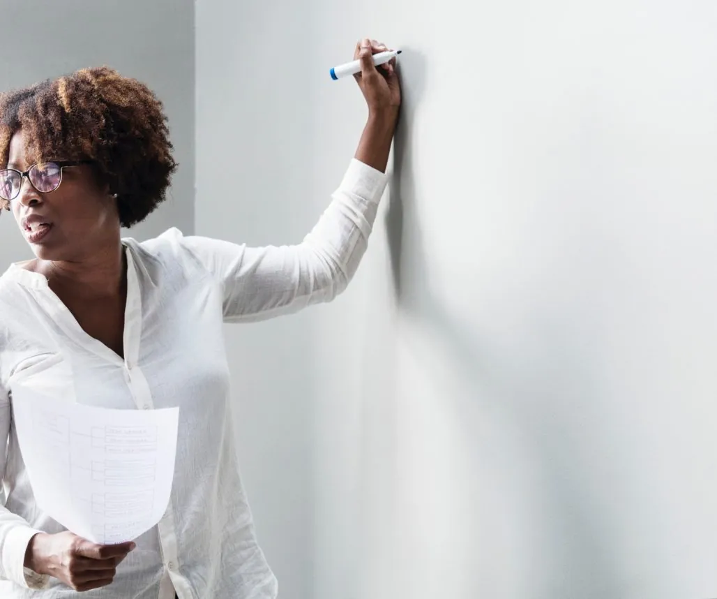 Intranet content series: a woman in white shirt is writing on a white board