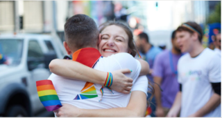 Man & woman embracing at Pride Parade