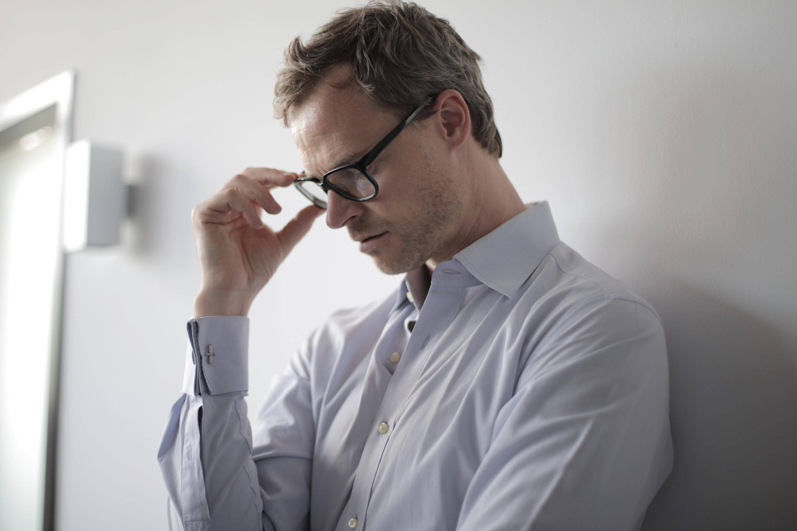 A man wearing black spectacles, represents the causes of employee turnover such as burnout and workplace pressure