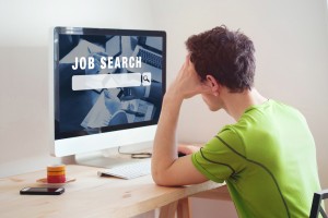 Employee sitting in front of a computer searching for jobs online