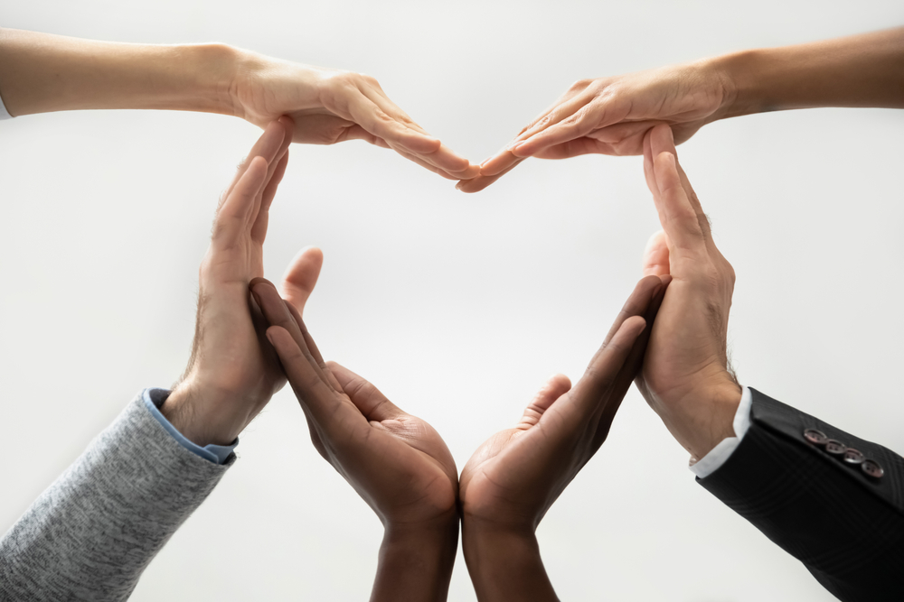 Employees forming a heart shape with their hands
