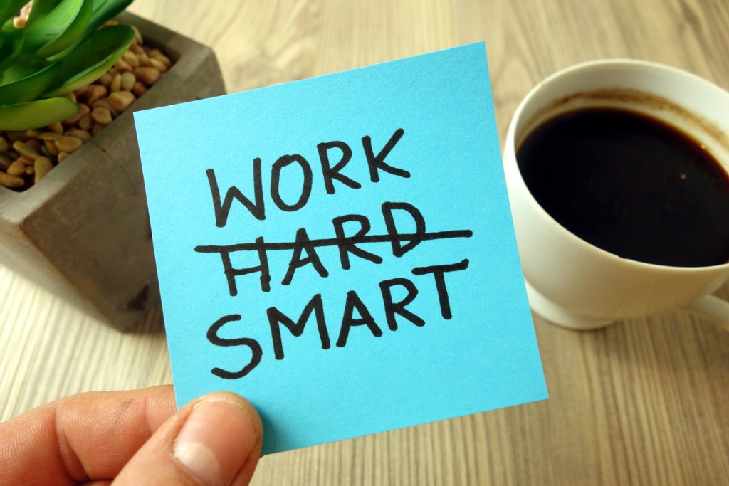 Motivational reminder written on a post-it that says work smart with hard crossed out