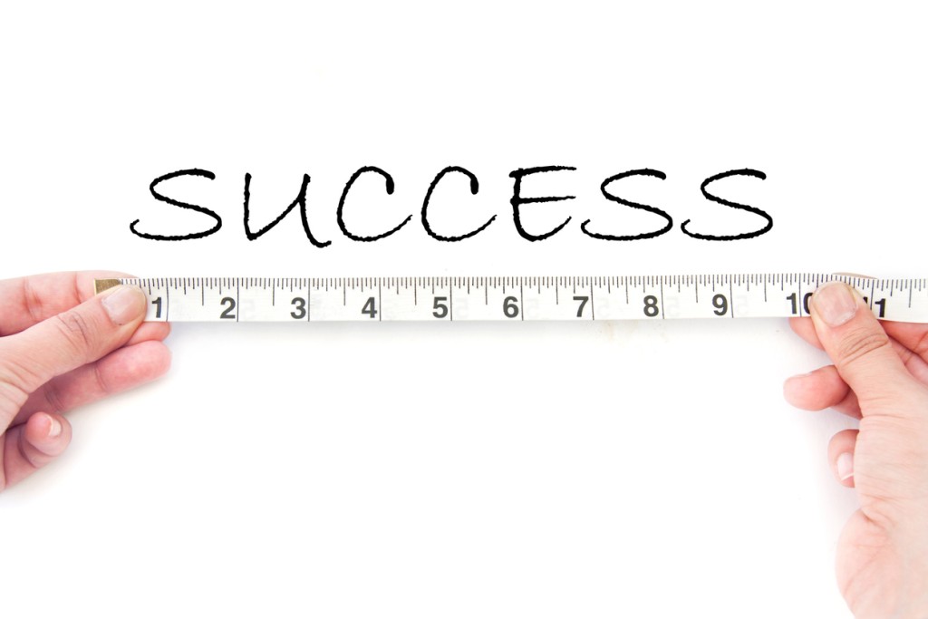 Person holding measuring tape with the word success above it