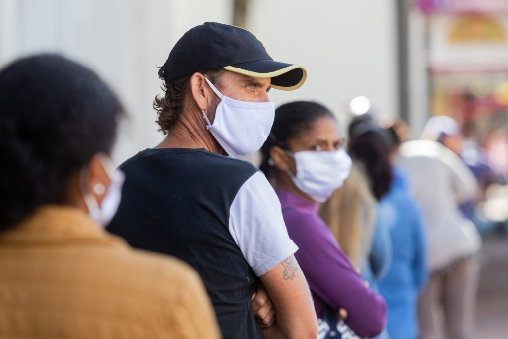Recruitment and retention - line of people wearing masks waits to receive service