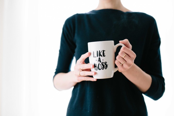 Employee experience - woman holding a coffee mug with the phrase "like a boss" written on it