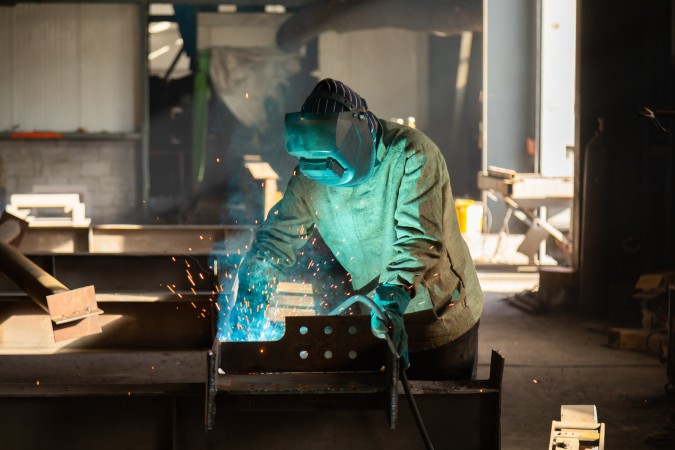 Deskless workers - person using welding gear while welding