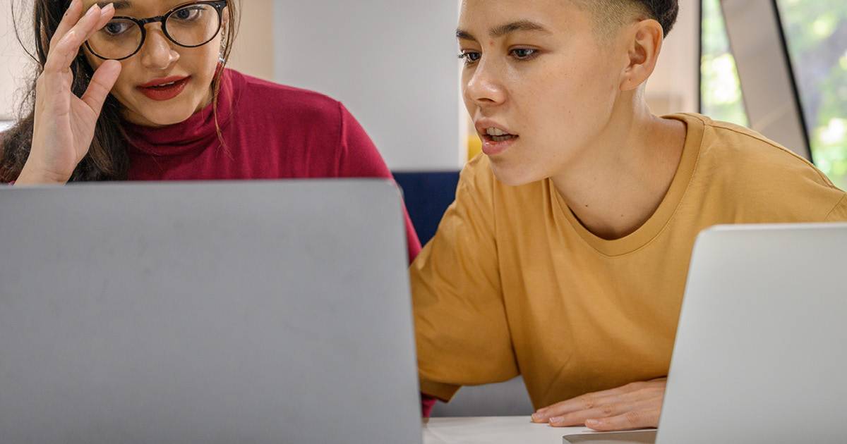 Tech debt evaluation - two employees working together on a laptop computer