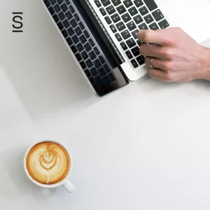 Intranet content - overhead shot of a laptop keyboard and a cup of coffee with a milk pattern
