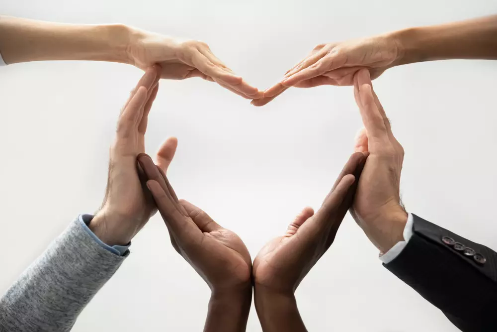 Employee relations: People forming a heart shape with their hands