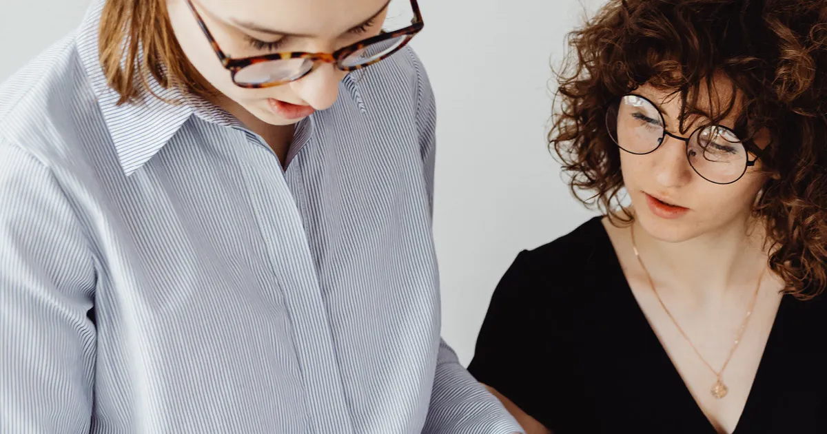 Intranet ROI - two women with glasses collaborating