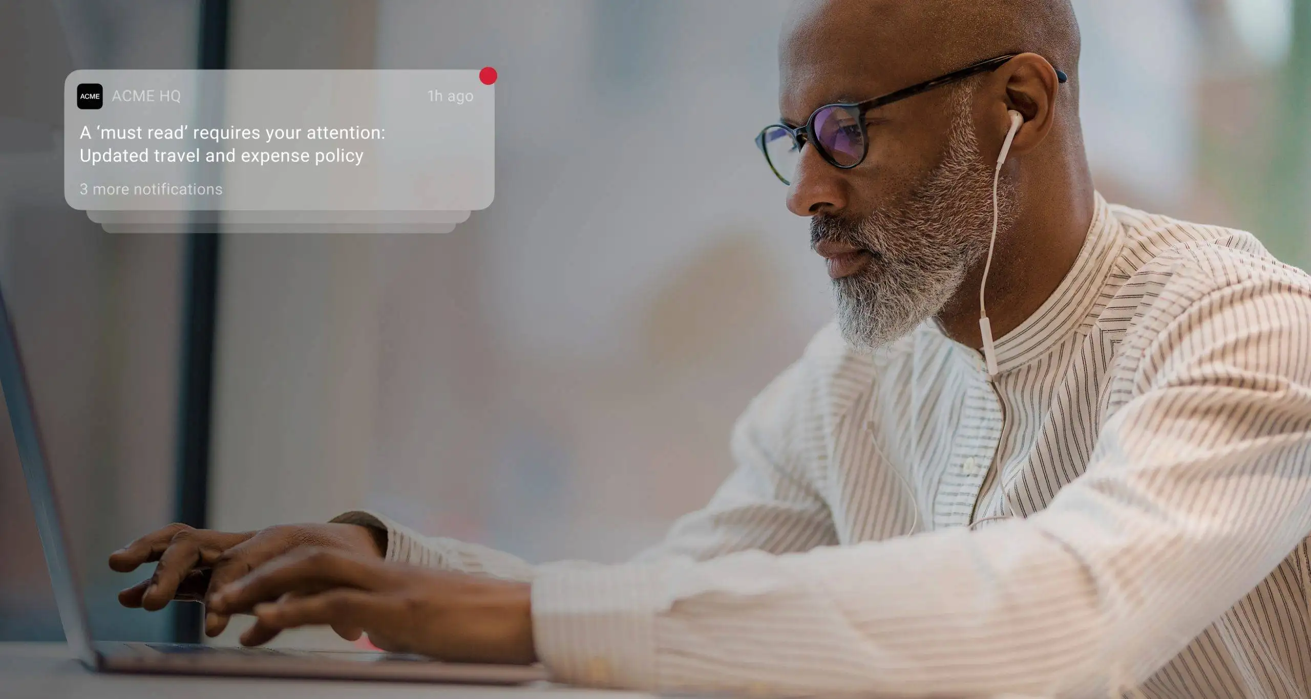 An employee receives a notification on their laptop about the updated company policy, enhancing two-way communication through the intranet.