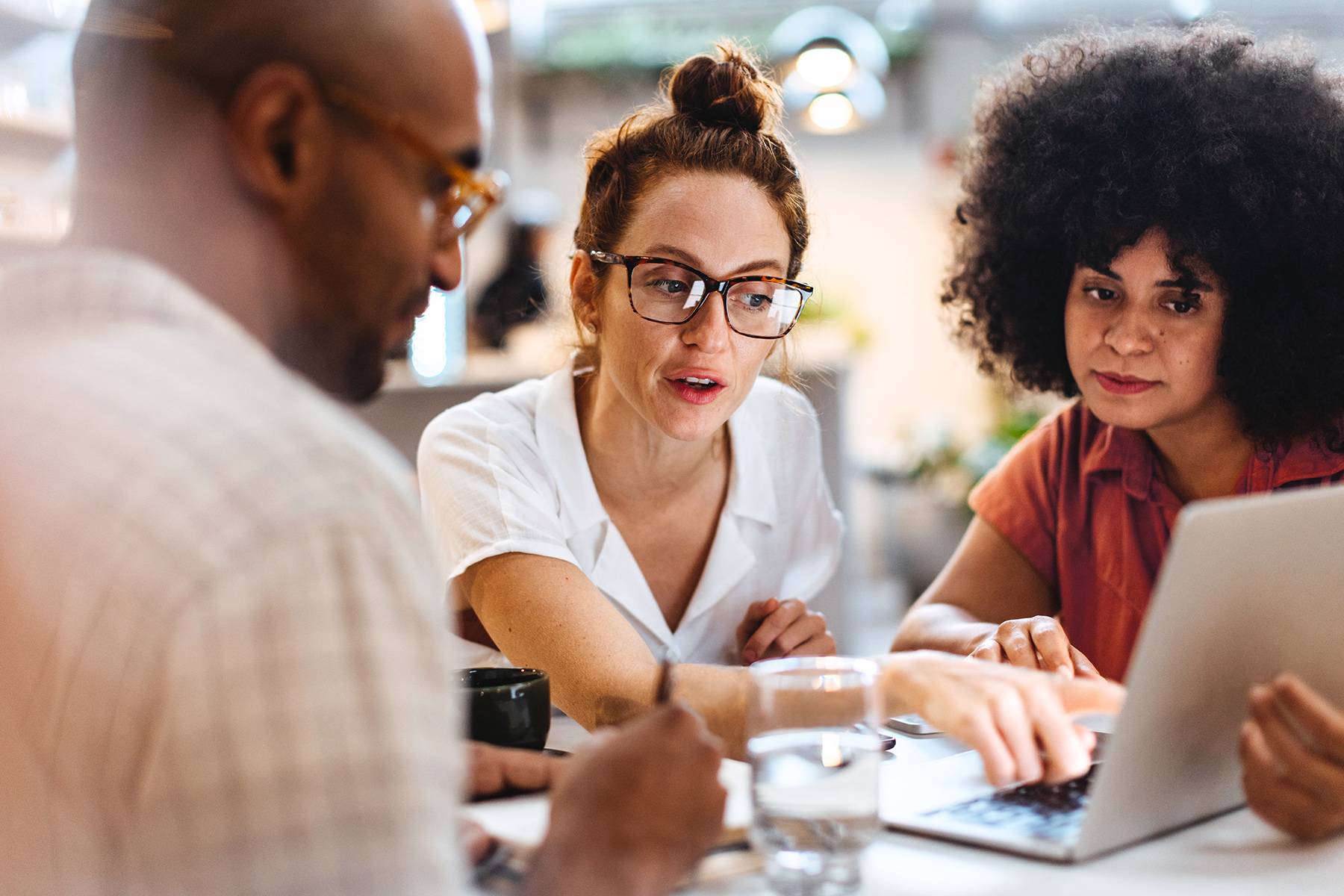 A male and two female team members are working on a laptop to streamline their workflow and enhance task efficiency.