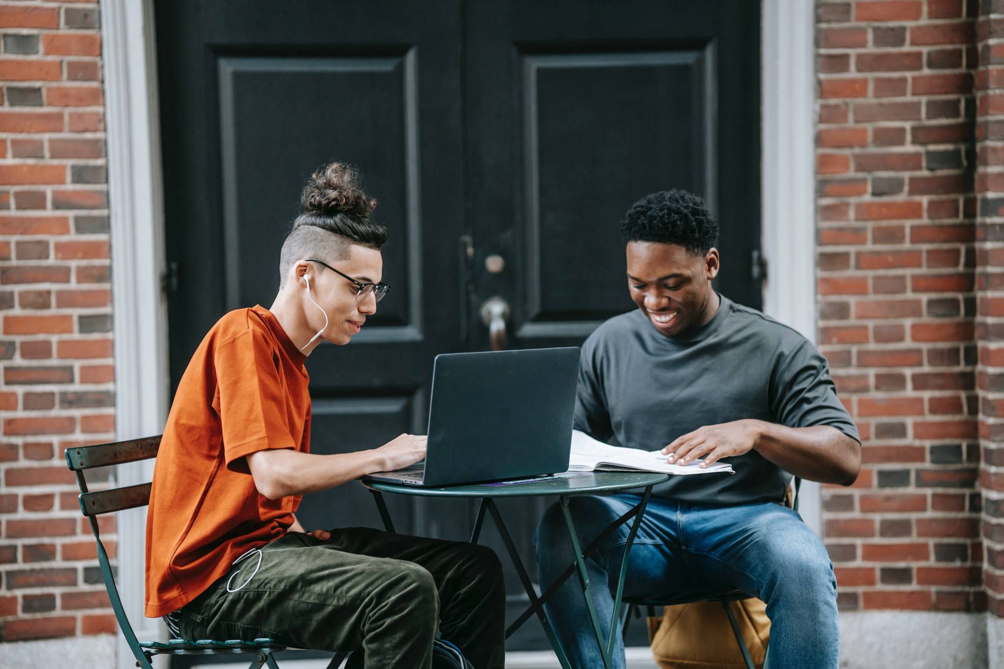 Financial services - two young men working on laptops outside