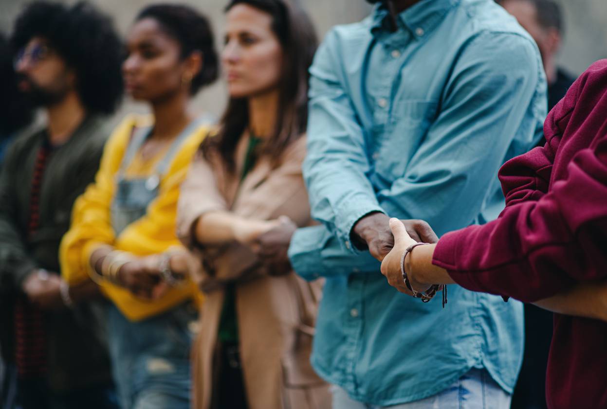Employee engagement - group of activists marching together and holding hands in solidarity