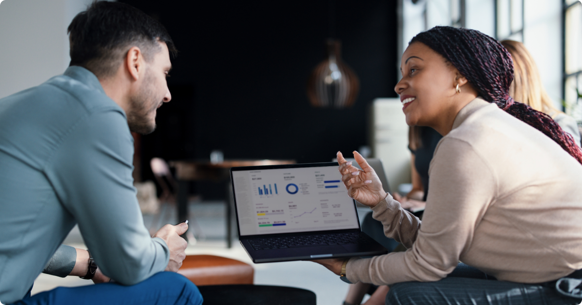 Two employees analyzing workforce data on a digital dashboard using people analytics tools.
