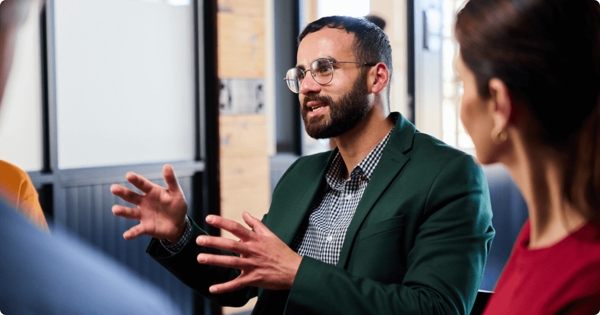 Person engaging expressively in a lively, conversation-style discussion with others.