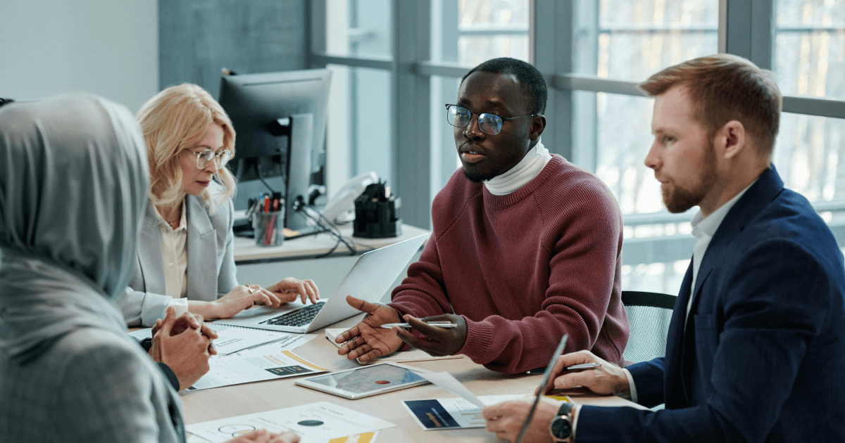 CIOs and the leadership team discussing Simpplr's digital transformation strategies at a conference table.