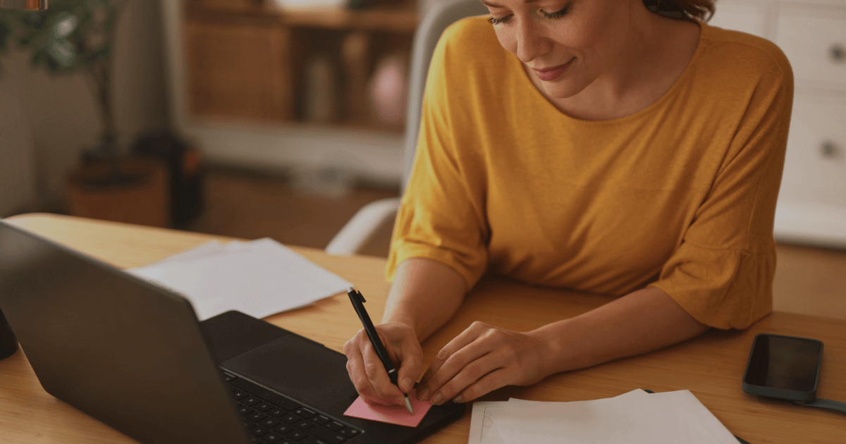 Manager writing a short handwritten thank-you note to appreciate employees.
